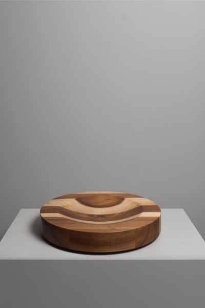 Wooden bowl with a striped design on a gray surface and background