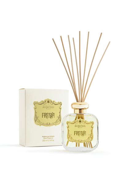 Fresia yellow diffuser bottle with reeds and packaging on a white background packaging reads "Santa Maria Novella Fresia"