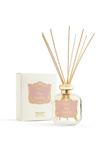 A clear glass diffuser bottle with a golden cap, labeled 'Rosa Gardenia' by Santa Maria Novella, accompanied by eight wooden sticks for diffusing the fragrance.